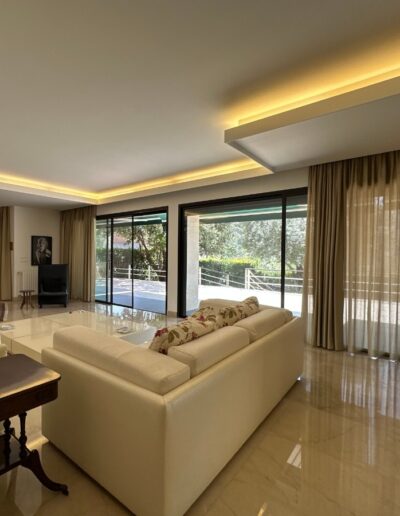 Installation d'un éclairage LED indirect en corniche de plafond dans un salon moderne